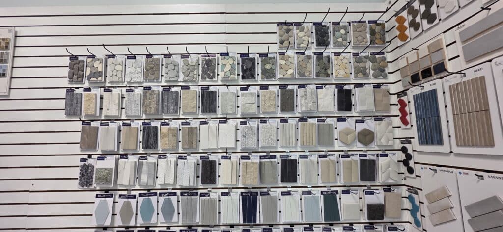 Pool tile samples and finish options on the material selection wall at Innovative Outdoor Living's Jupiter showroom