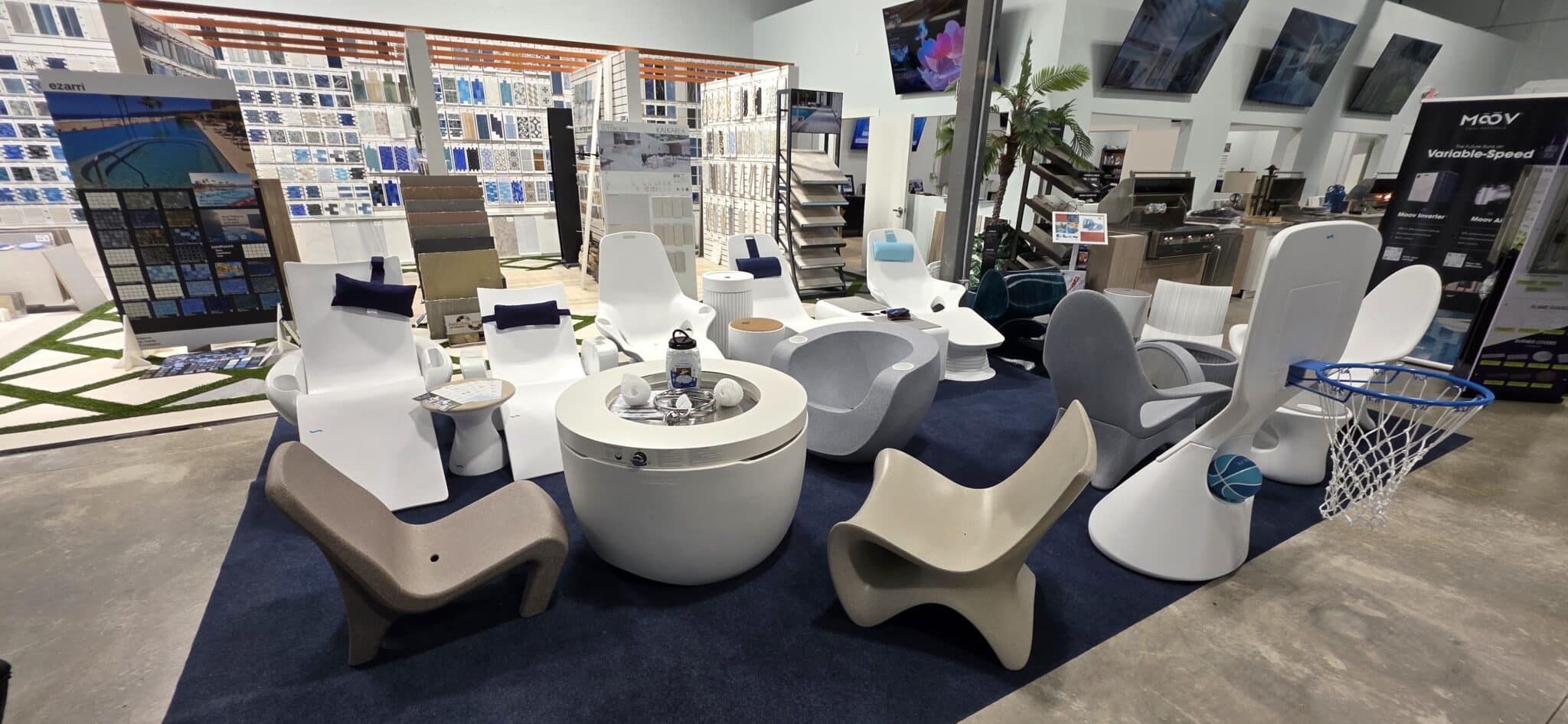White and gray pool loungers, seating and side tables displayed at Innovative Outdoor Living's Jupiter showroom